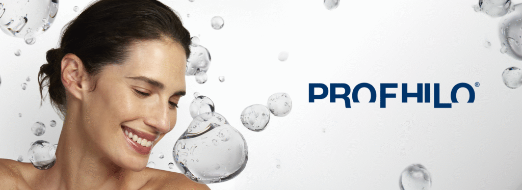 Mulher sorridente de pele saudável e iluminada, cercada por bolhas translúcidas, com a marca Profhilo destacada ao lado.